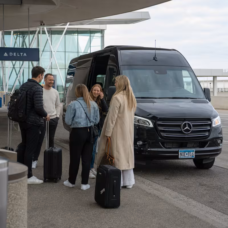 Group boarding a white charter bus for Airport Transportation transportation in Minneapolis