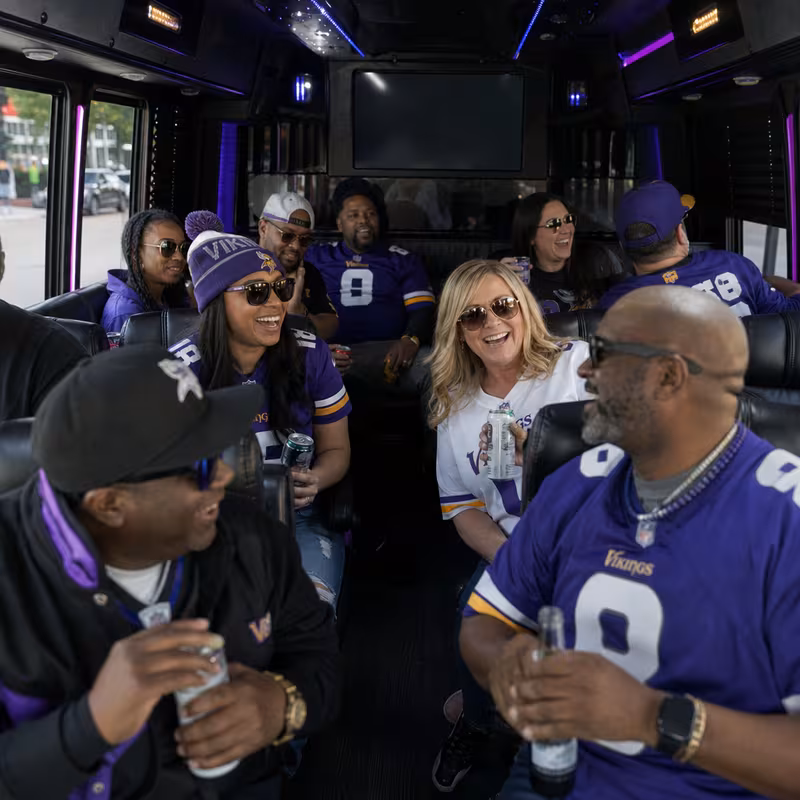 Group boarding a white charter bus for Sporting Event Transportation transportation in Minneapolis